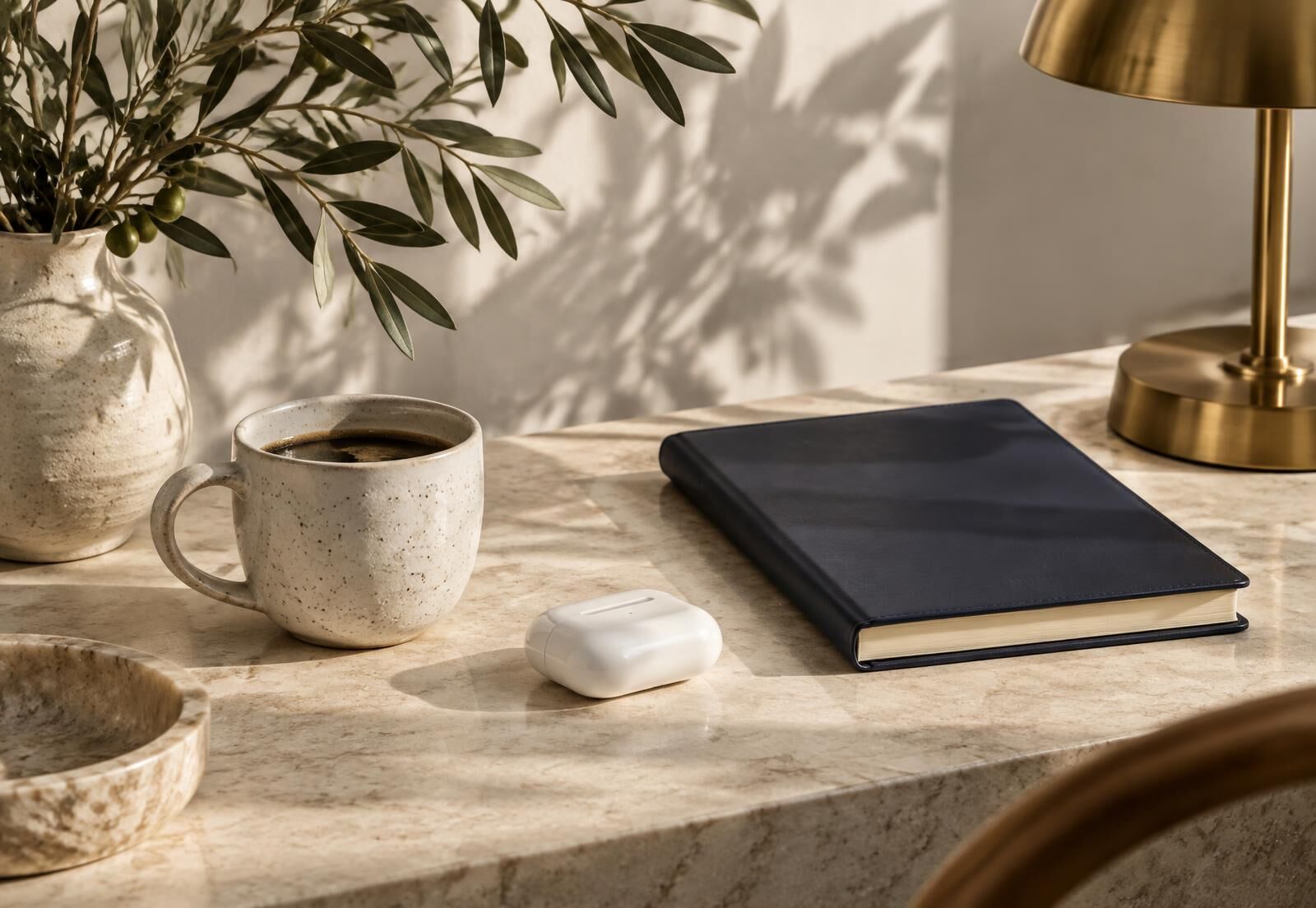 Curated everyday objects on a stone desk in soft daylight